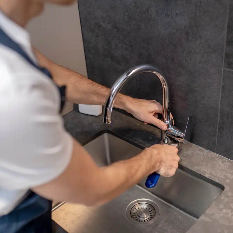 plumber using wrench to repair faucet in zachary la