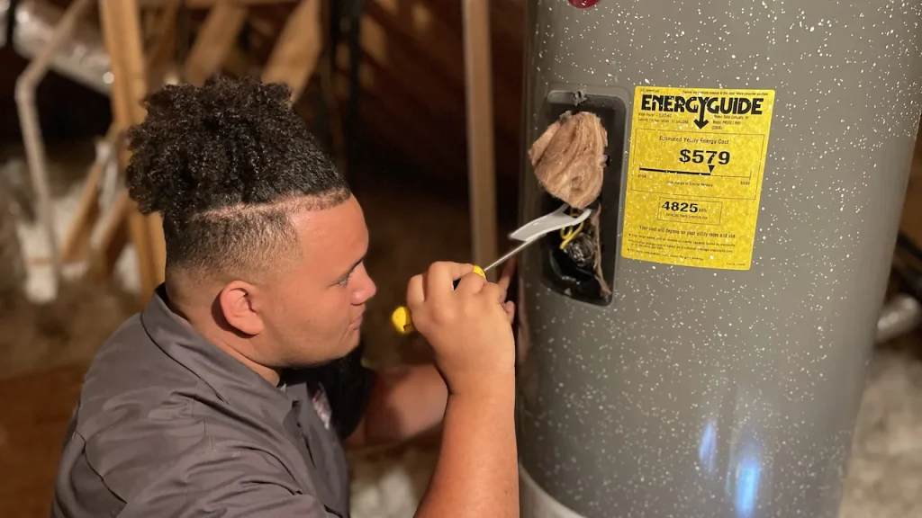 hero size zachary plumbing technicial claning hot water heater